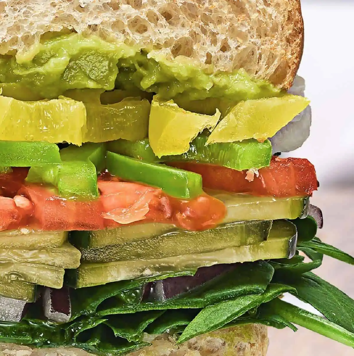 Side view of a Subway veggie sub filled with lettuce, pickles, peppers, tomatoes and lettuce.