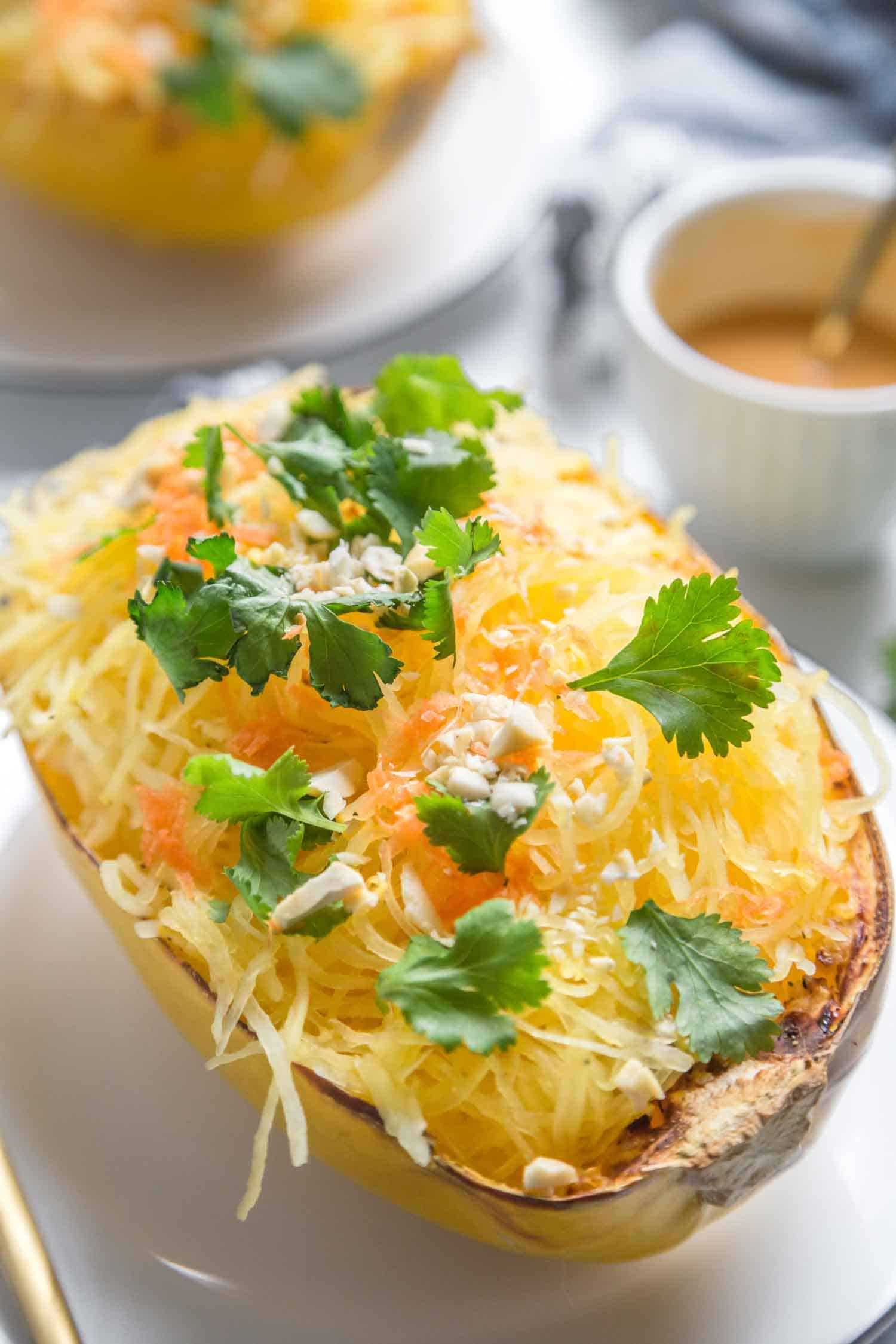 cooked spaghetti squash topped with a creamy vegan sauce and vegan parmesan and parsley