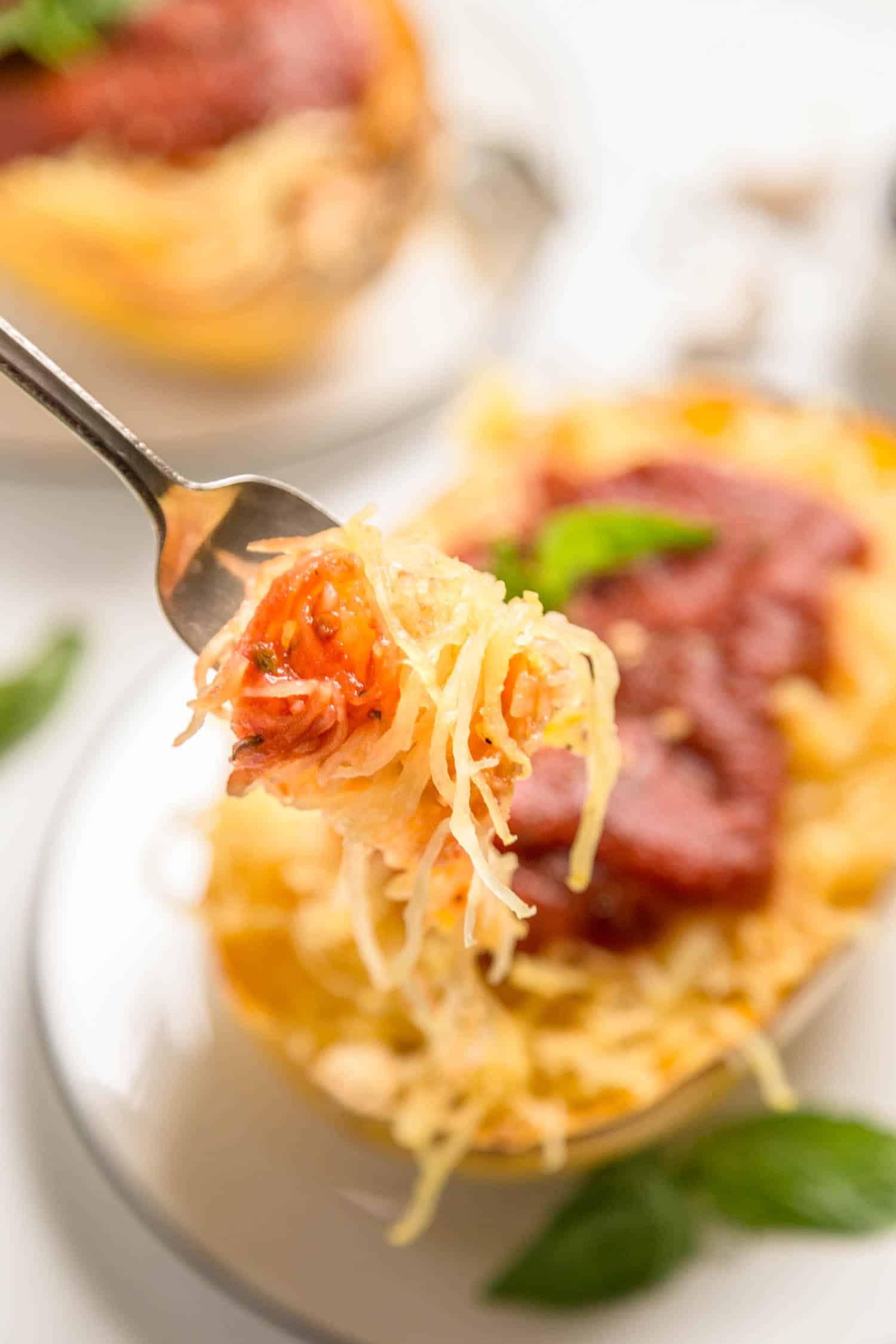 A fork full of spaghetti squash with tomato sauce