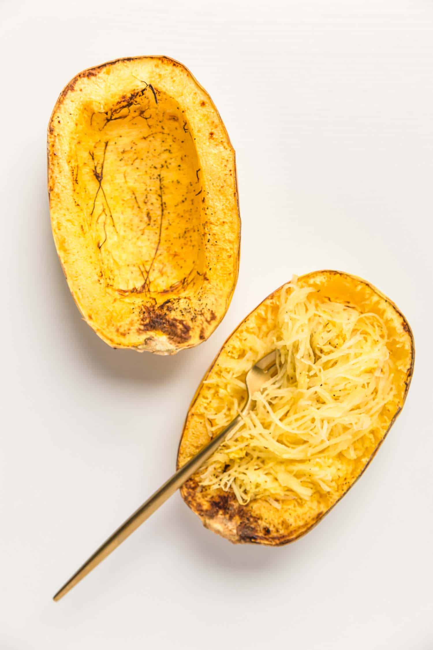 cooked spaghetti squash with noodle strands fluffed up with a fork  