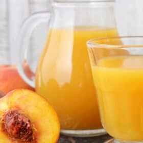 summer peach juice served in a large glass pitcher