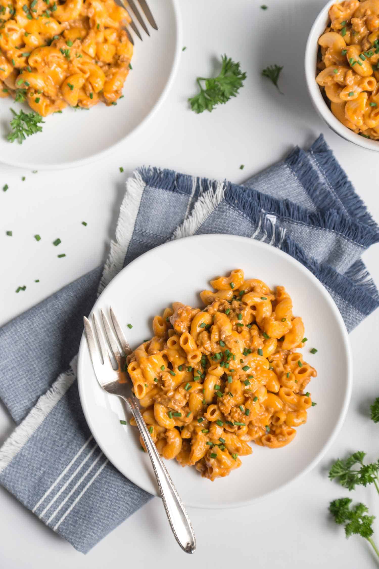 vegetarian hamburger helper served on a plate with a blue napkin and parsley