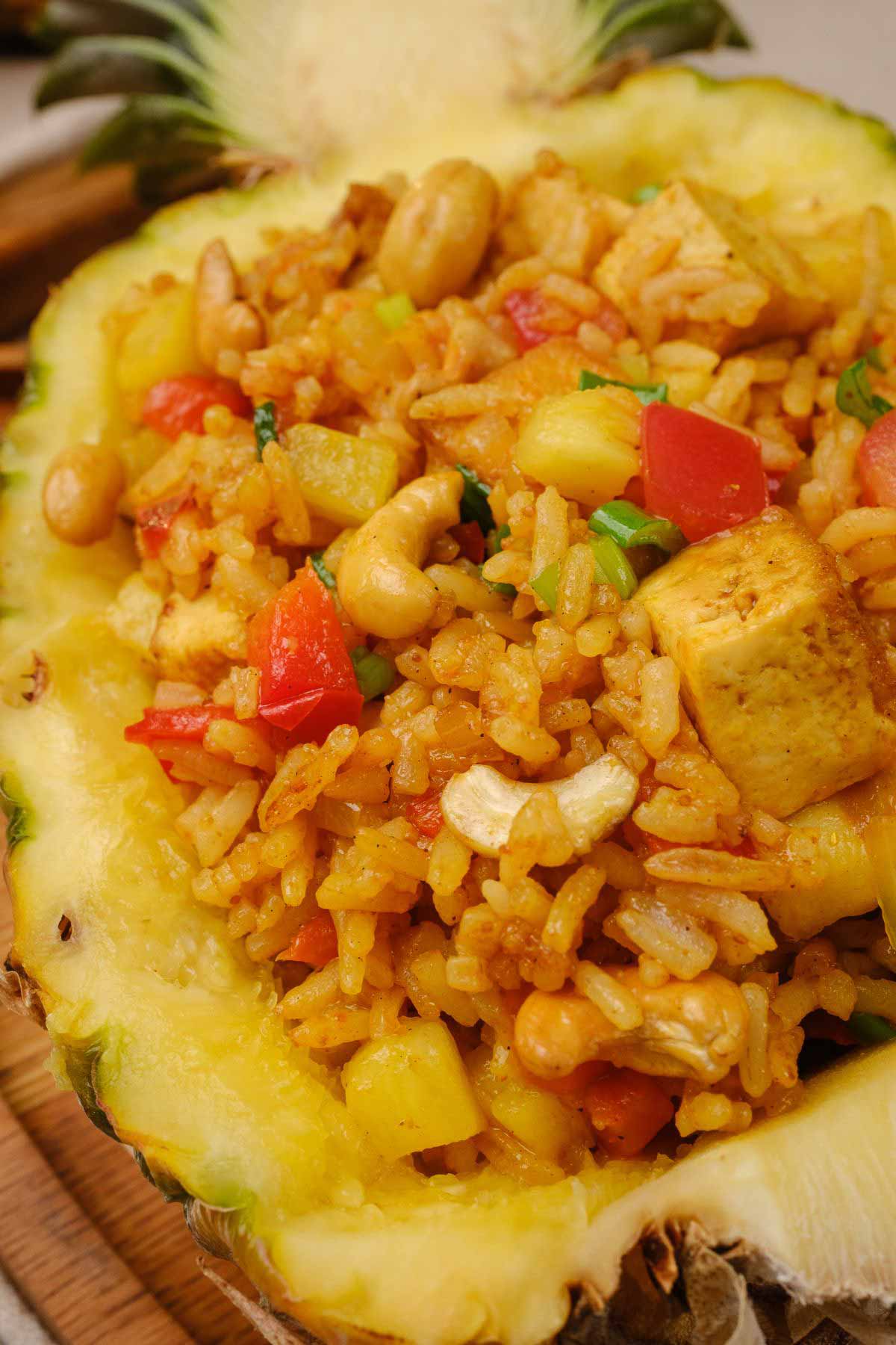 An angled shot of vegan pineapple fried rice served in a hollowed out pineapple.