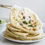A stack of fluffy, homemade vegan pita bread.