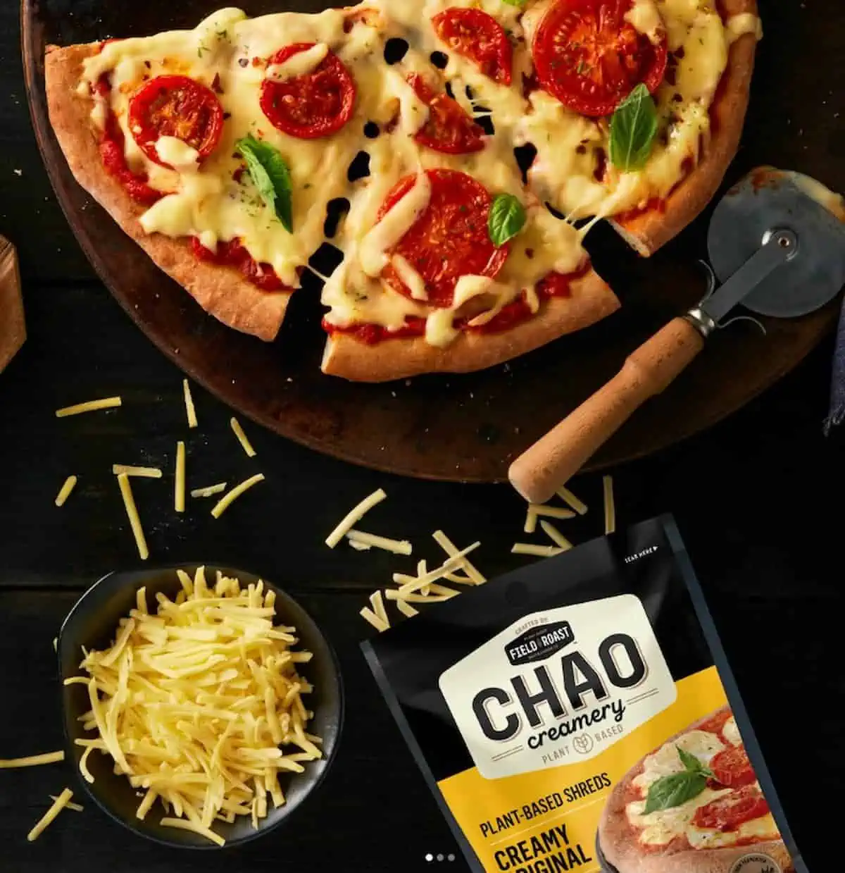 Vegan pizza next to a package of Field Roast Chao vegan cheese shreds.
