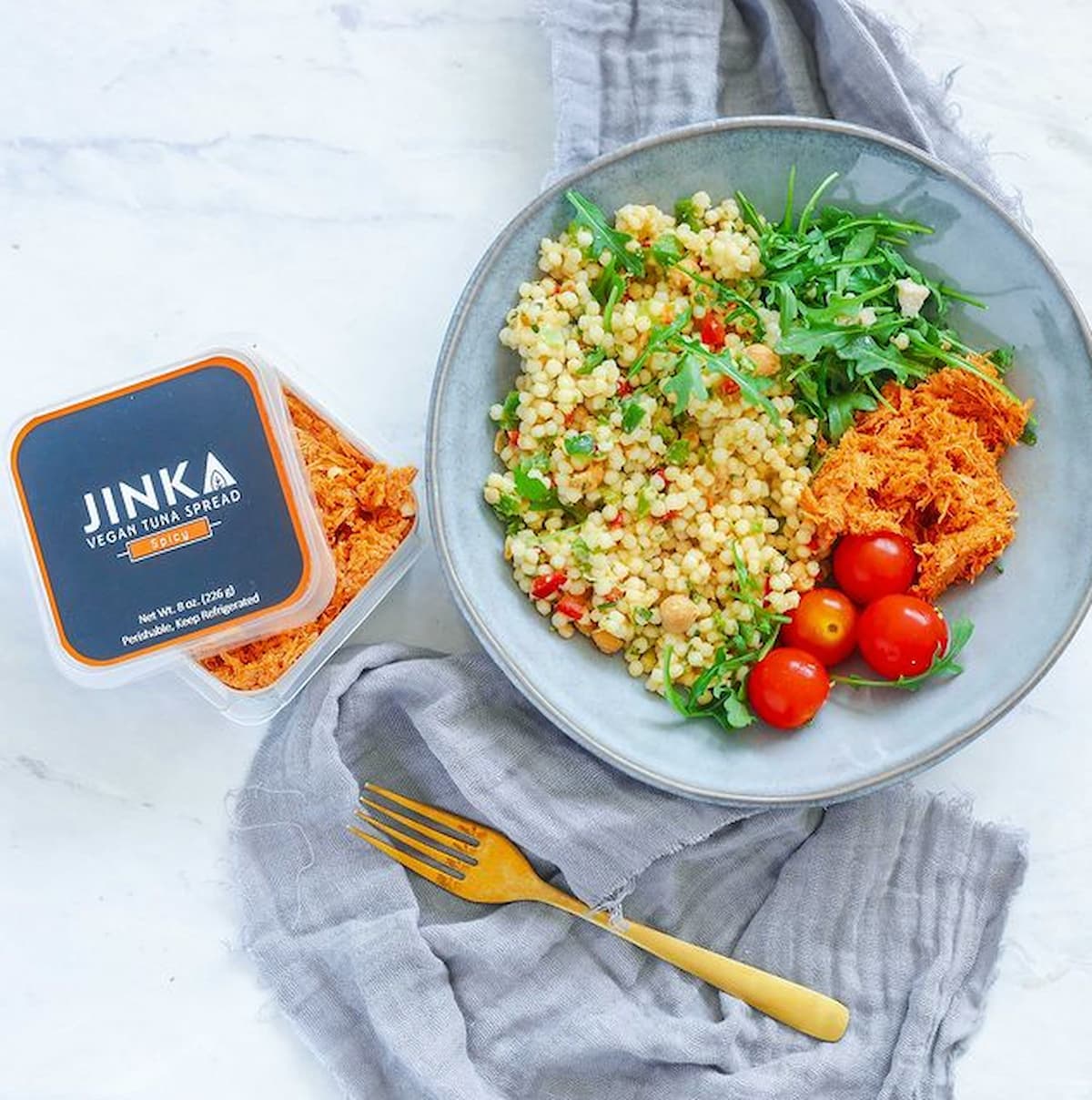 Vegan tuna on a salad next to Jink Vegan Tuna Spread container.