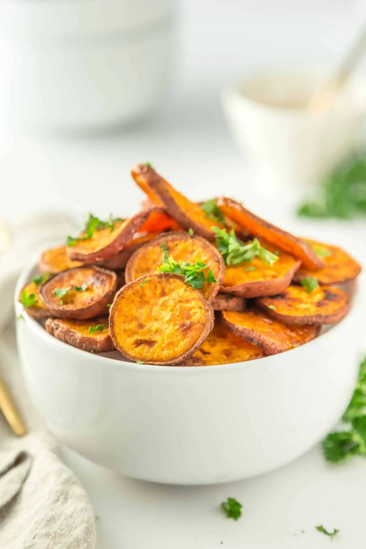 Roasted Baked Sweet Potato Slices in a white bowl with parsley garnish