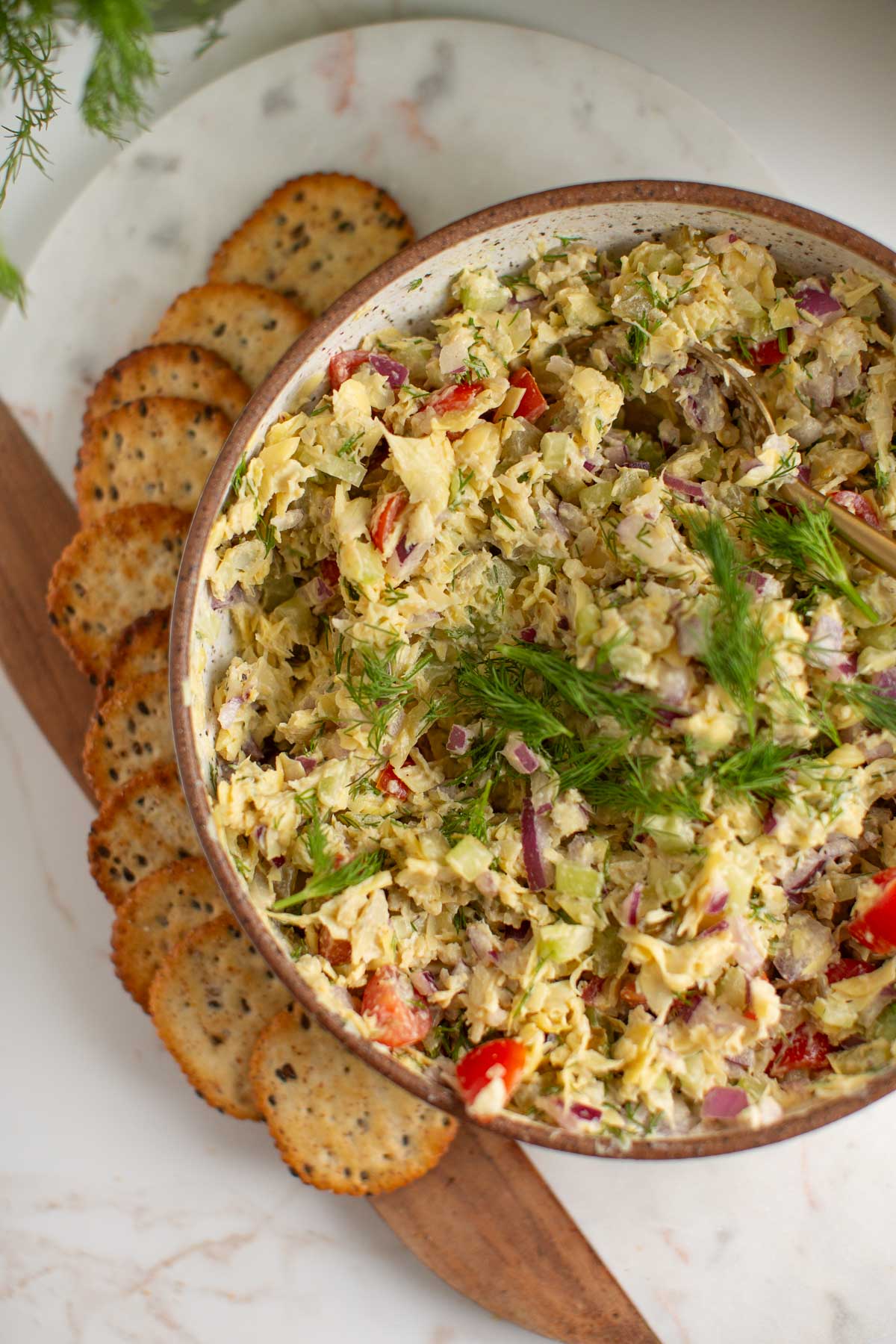 Artichoke tuna salad served in a bowl with Back to Nature crackers. 