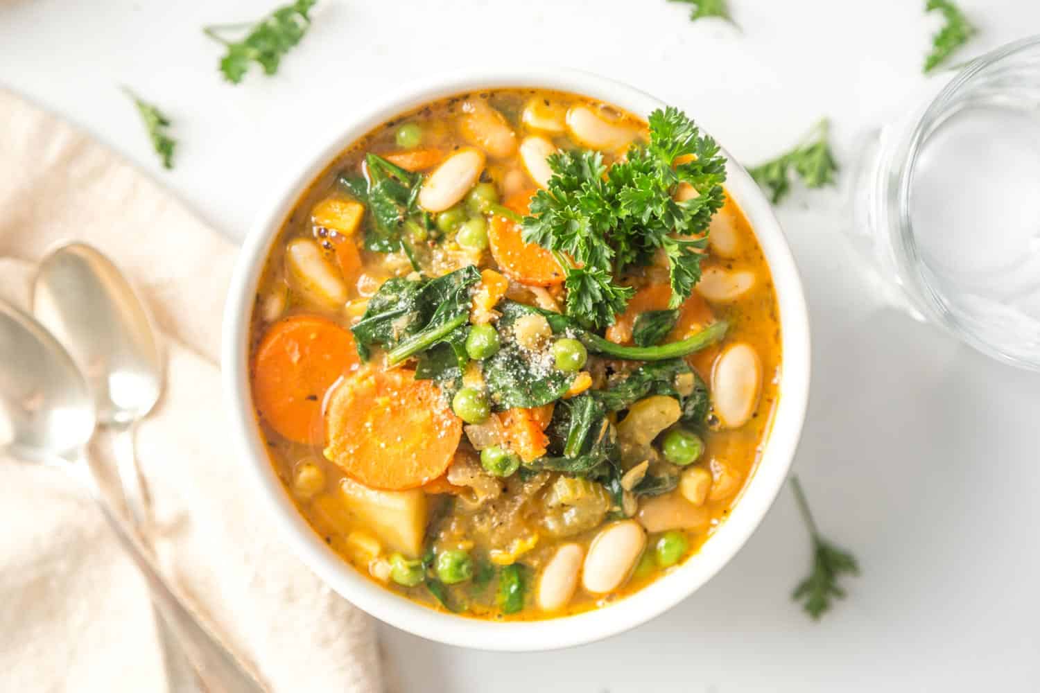 Vegan stew in a bowl, topped with fresh herbs.