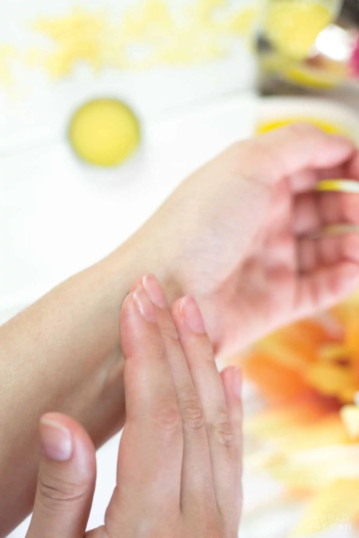 Hand rubbing solid perfume onto the other wrist.