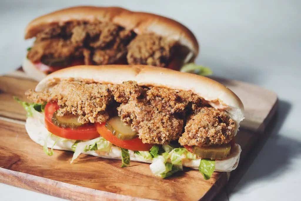 vegan po boy sandwiches with fried oyster mushrooms and pickles, tomatoes, and lettuce