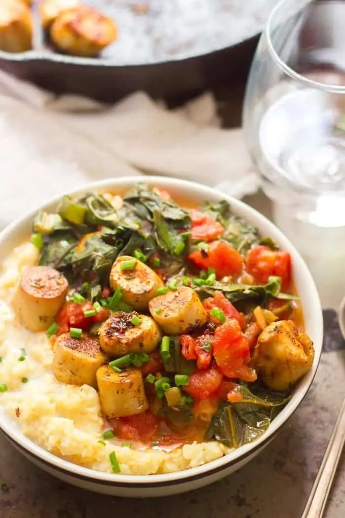 Vegan oyster mushroom scallops on a plate of grits.