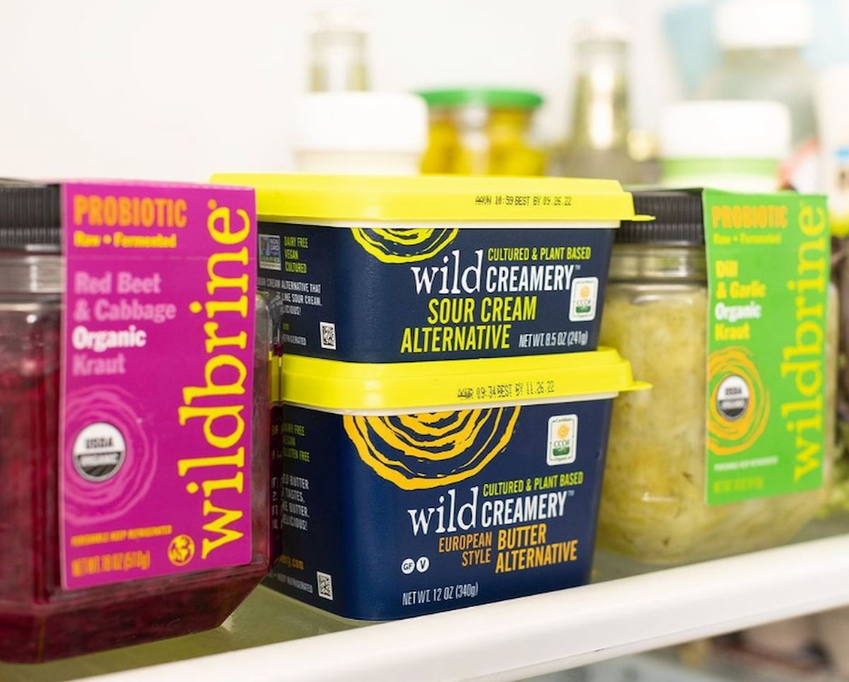 Container of Wild Brine's vegan sour cream in a refrigerator with other Wild Brine products.
