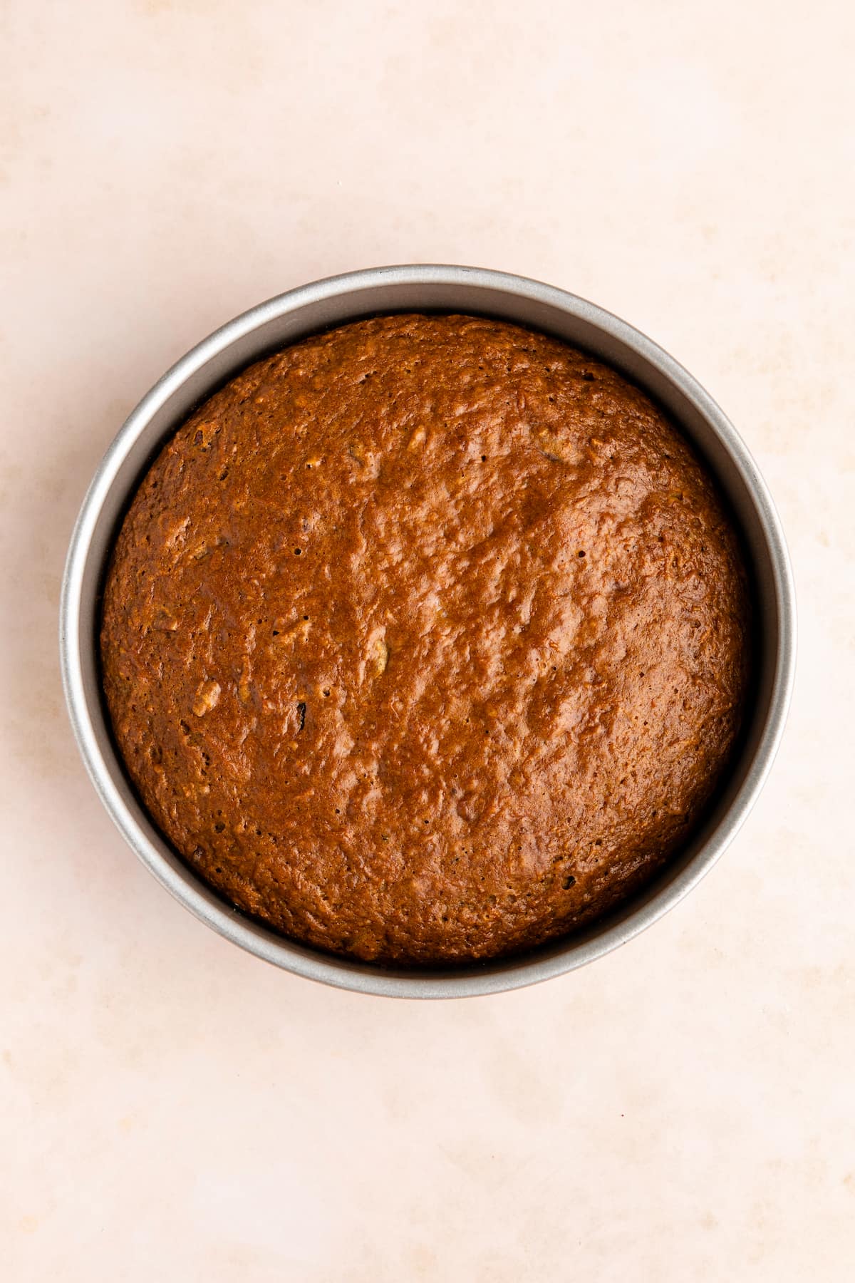 A vegan carrot cake in a cake tin, shot from the top down.