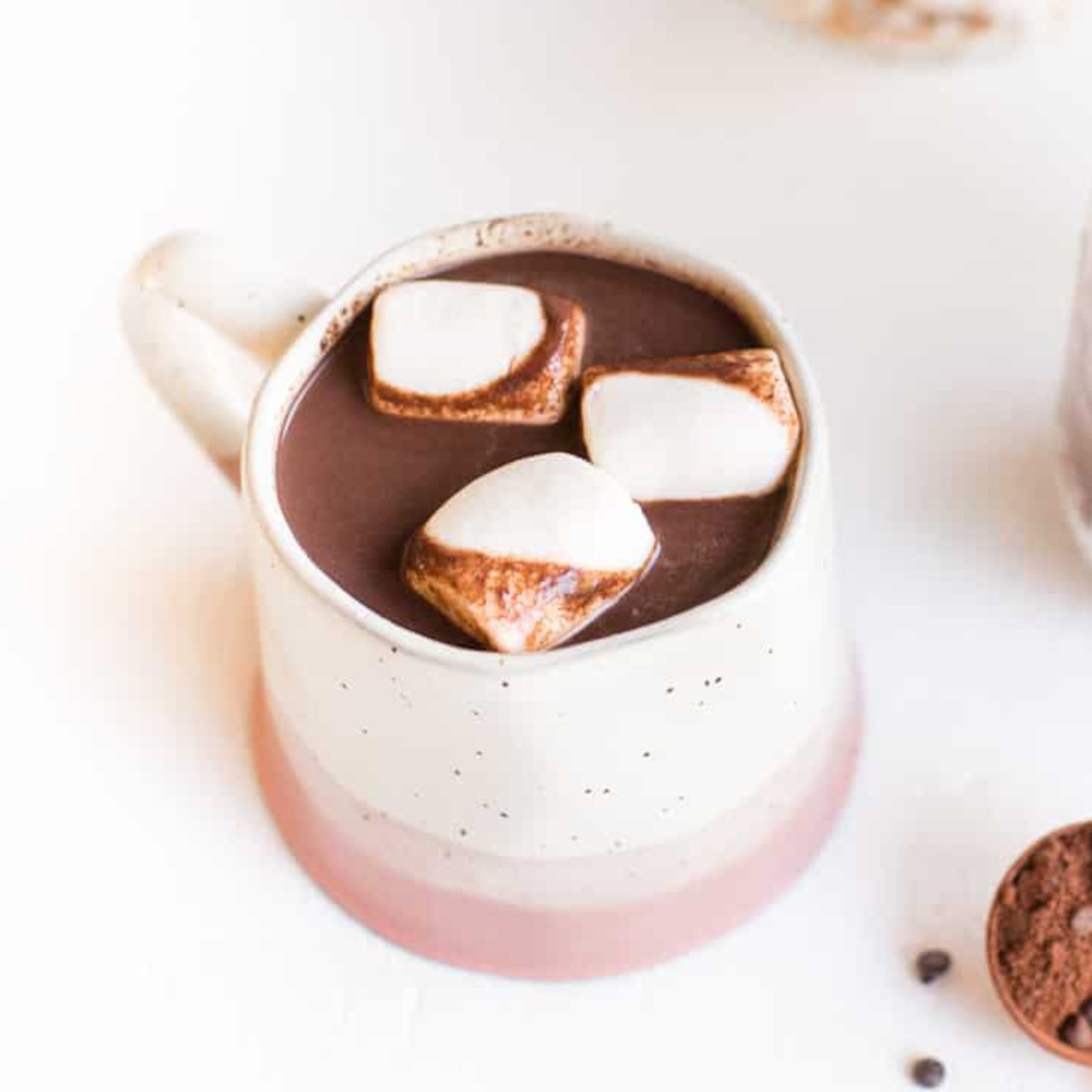 A mug of dairy-free hot chocolate, topped with vegan marshmallows.