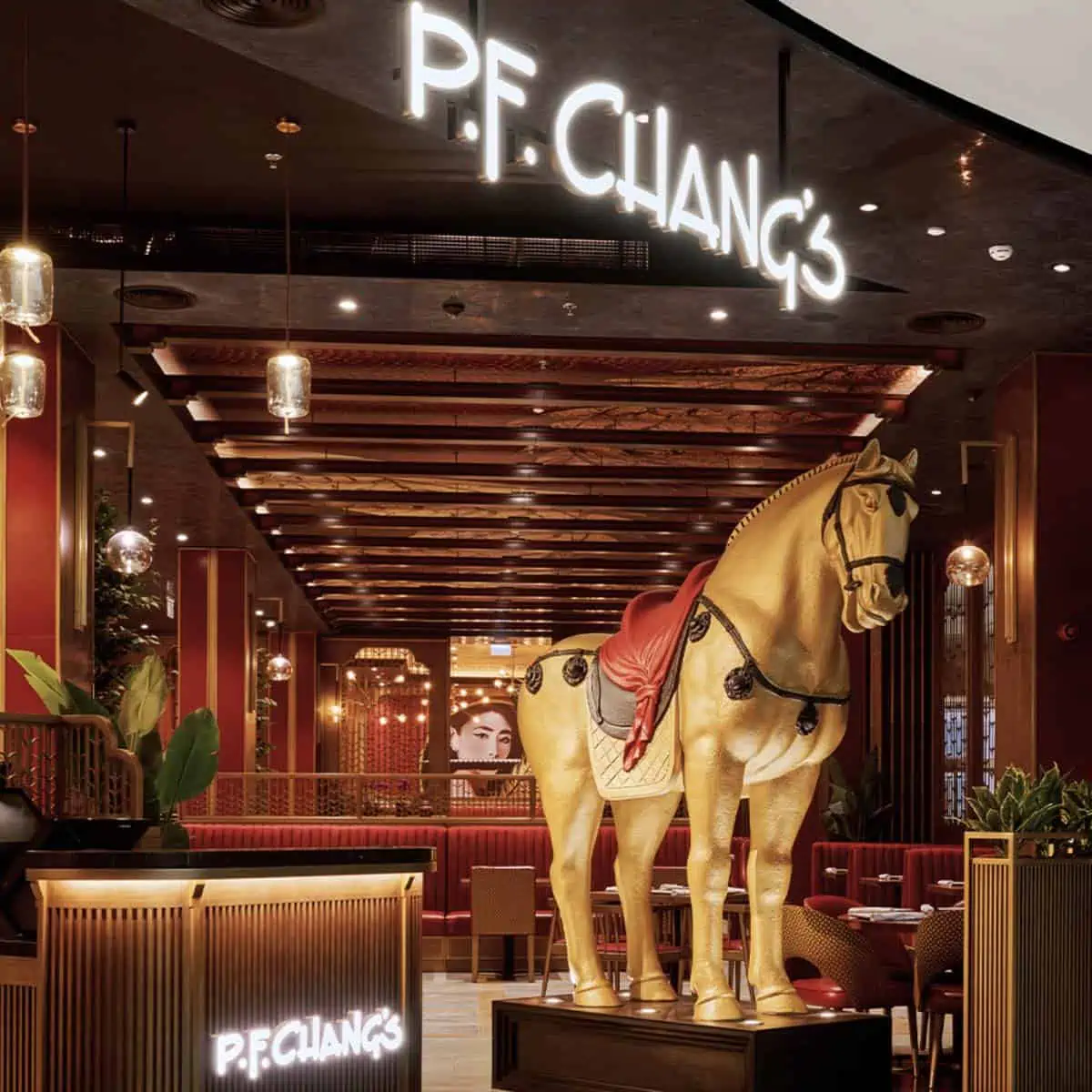 Inside the PF Changs restaurant with the horse statue and sign.
