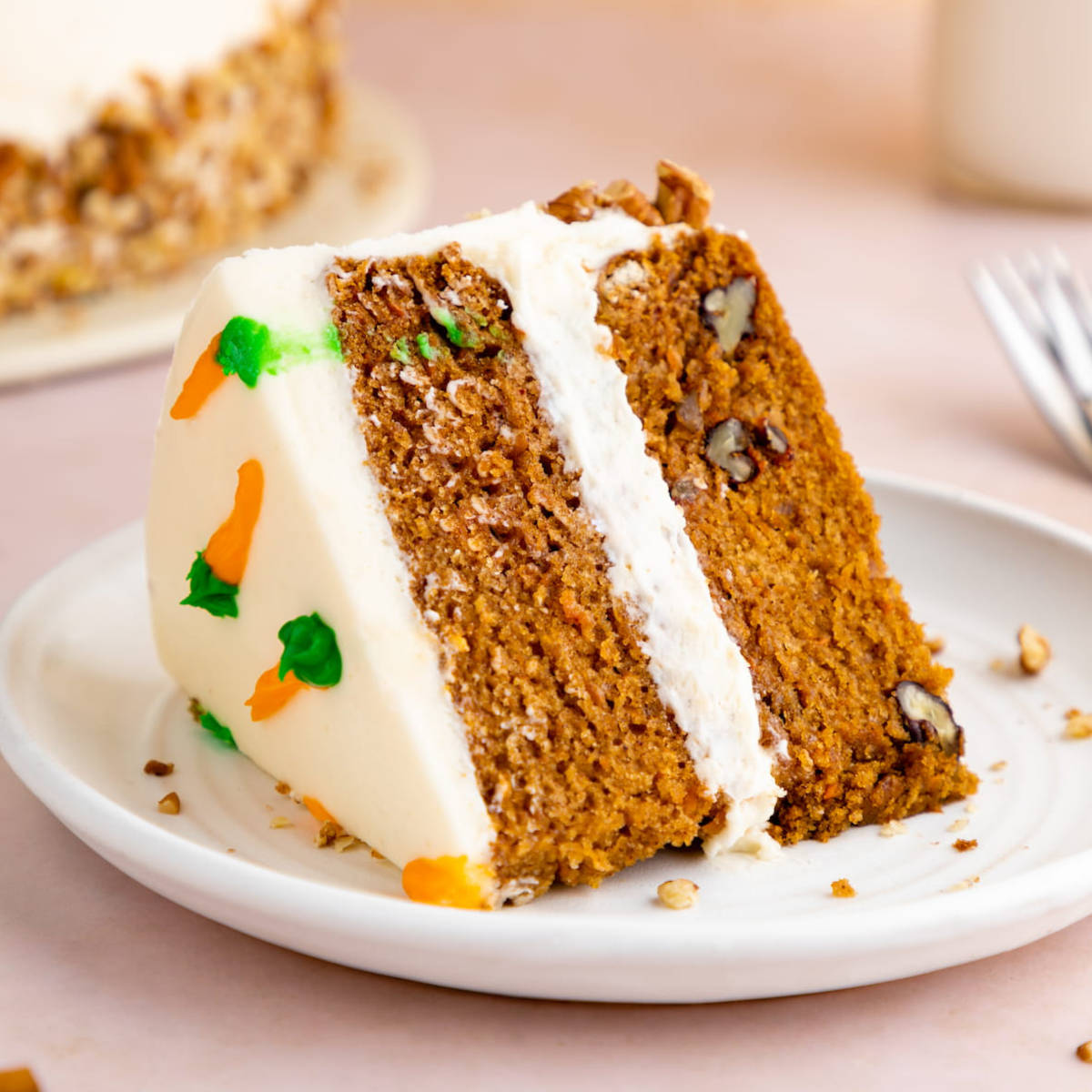 A slice of double layered vegan carrot cake on a plate.