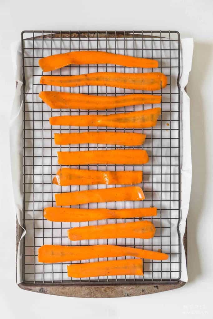 sliced marinated carrots on a baking sheet