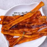 Strips of carrot bacon on a plate.