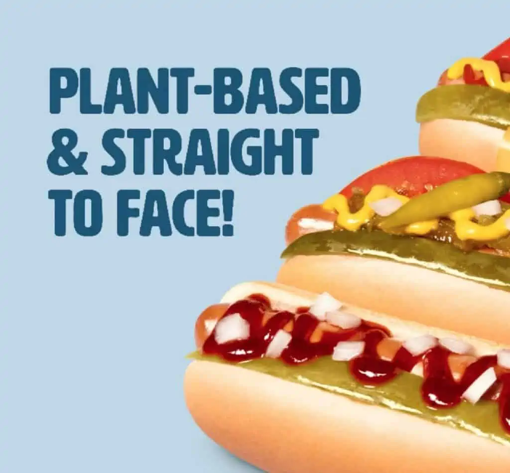 A light blue background with the words "Plant-Based and Straight to Face!" next to the profiles of three vegan, plant-based Field Roast veggie dogs on the Wienerschnitzel menu.