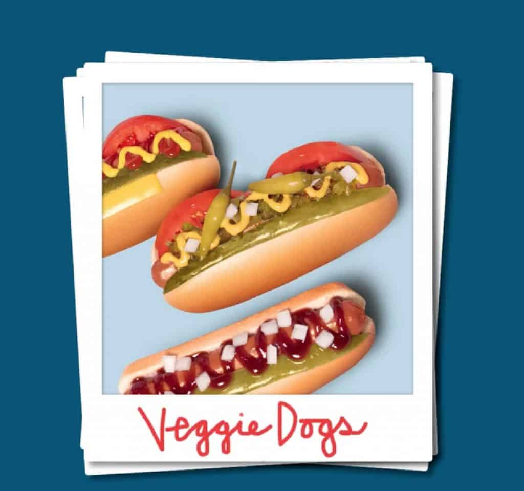 A blue background with showing a faux polaroid photo of three vegan, plant-based Field Roast veggie dogs offered at Wienerschnitzel.
