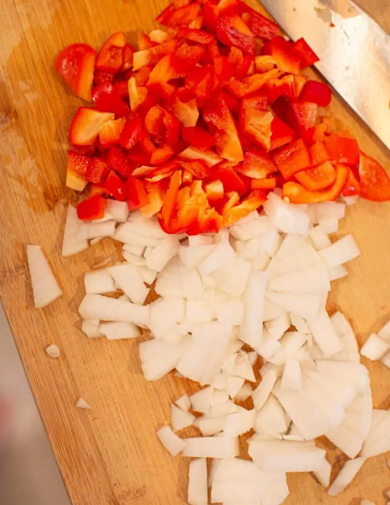 chopped onion and bell pepper on a cutting board