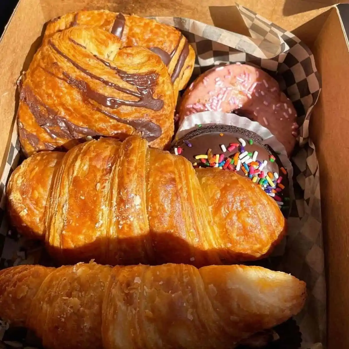 bakery box filled with vegan croissants and pain au chocolat and donuts