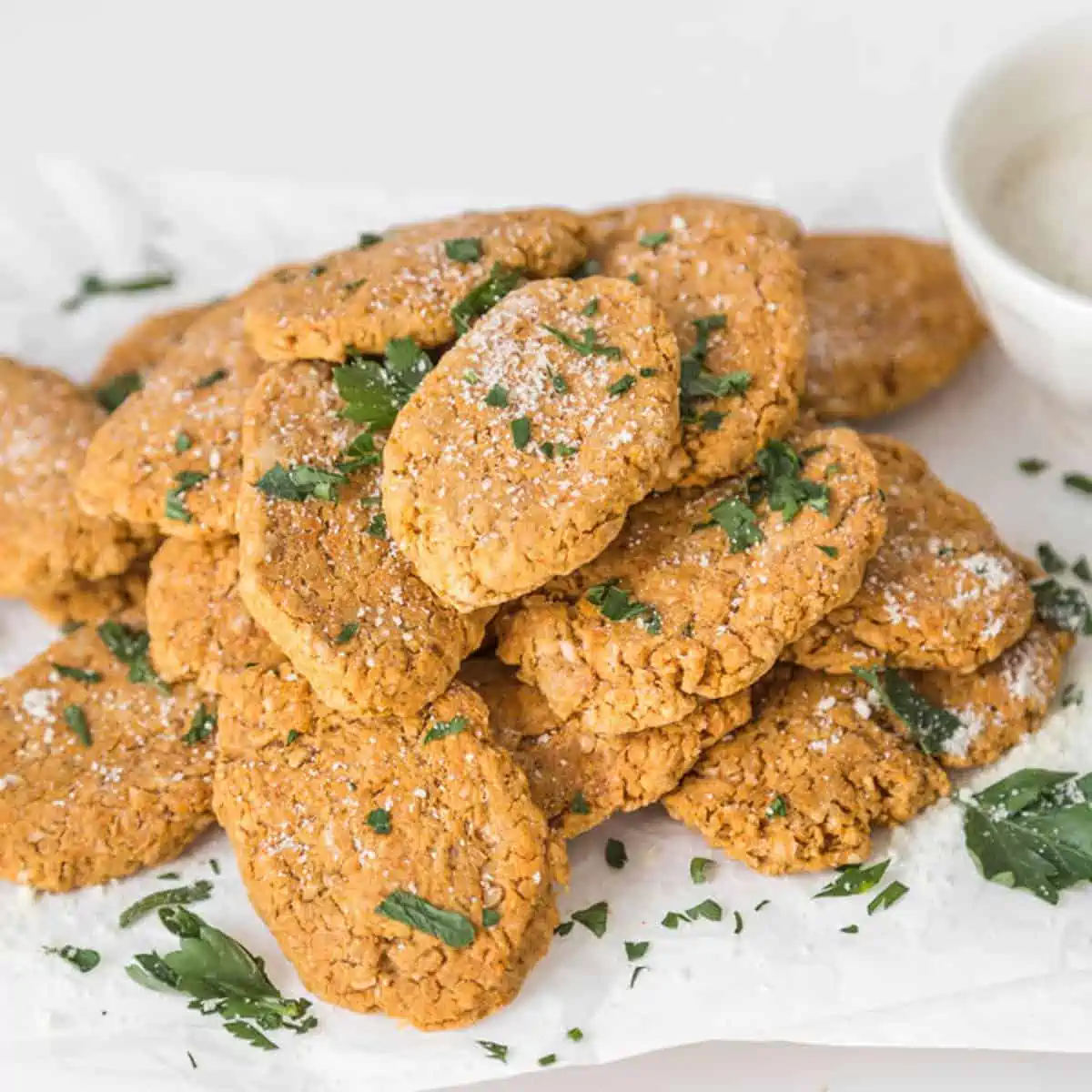 Pile of chickpea nuggets sprinkled with fresh chopped herbs.