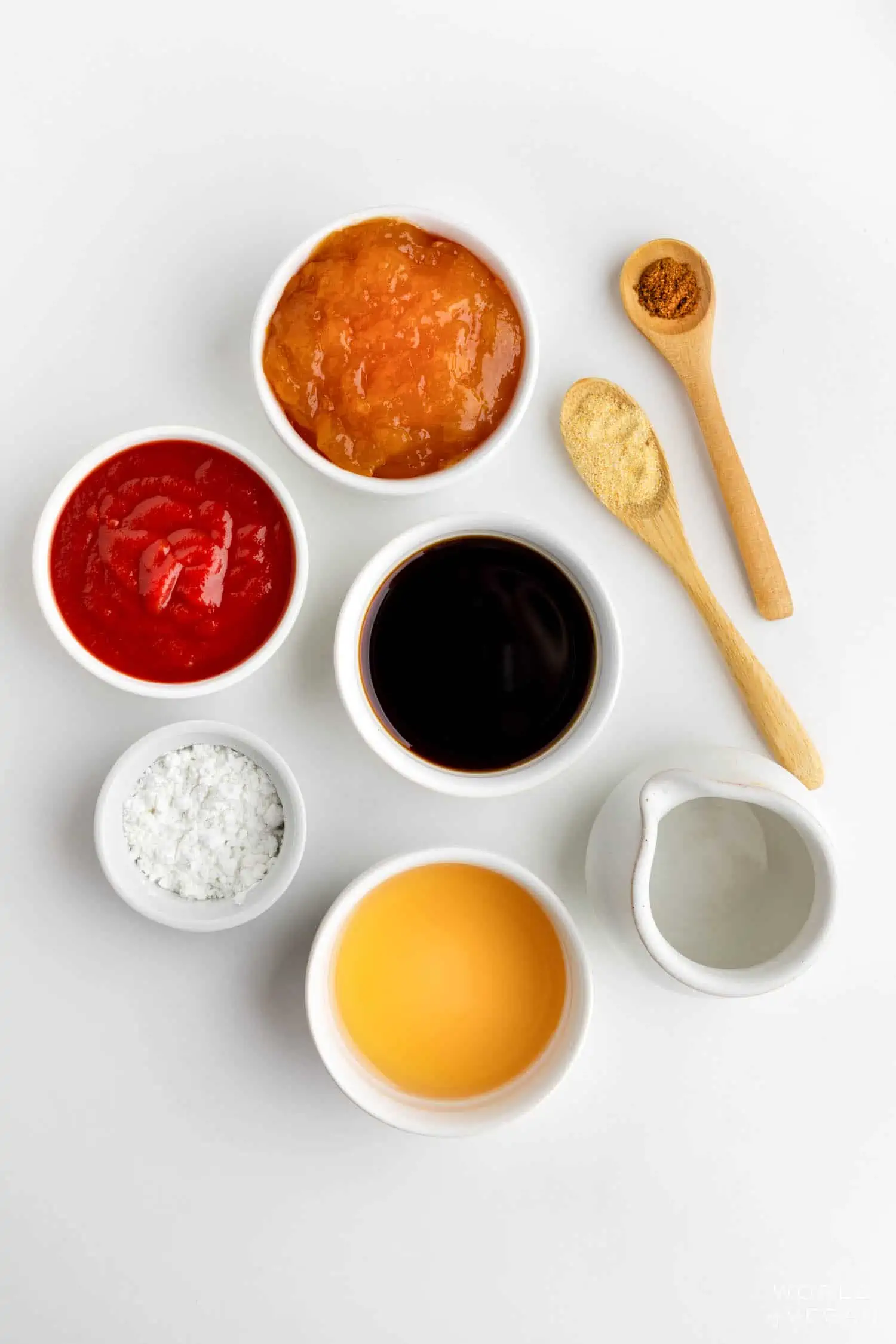 Sweet and sour sauce ingredients flatlay with ketchup jam soy sauce and more.