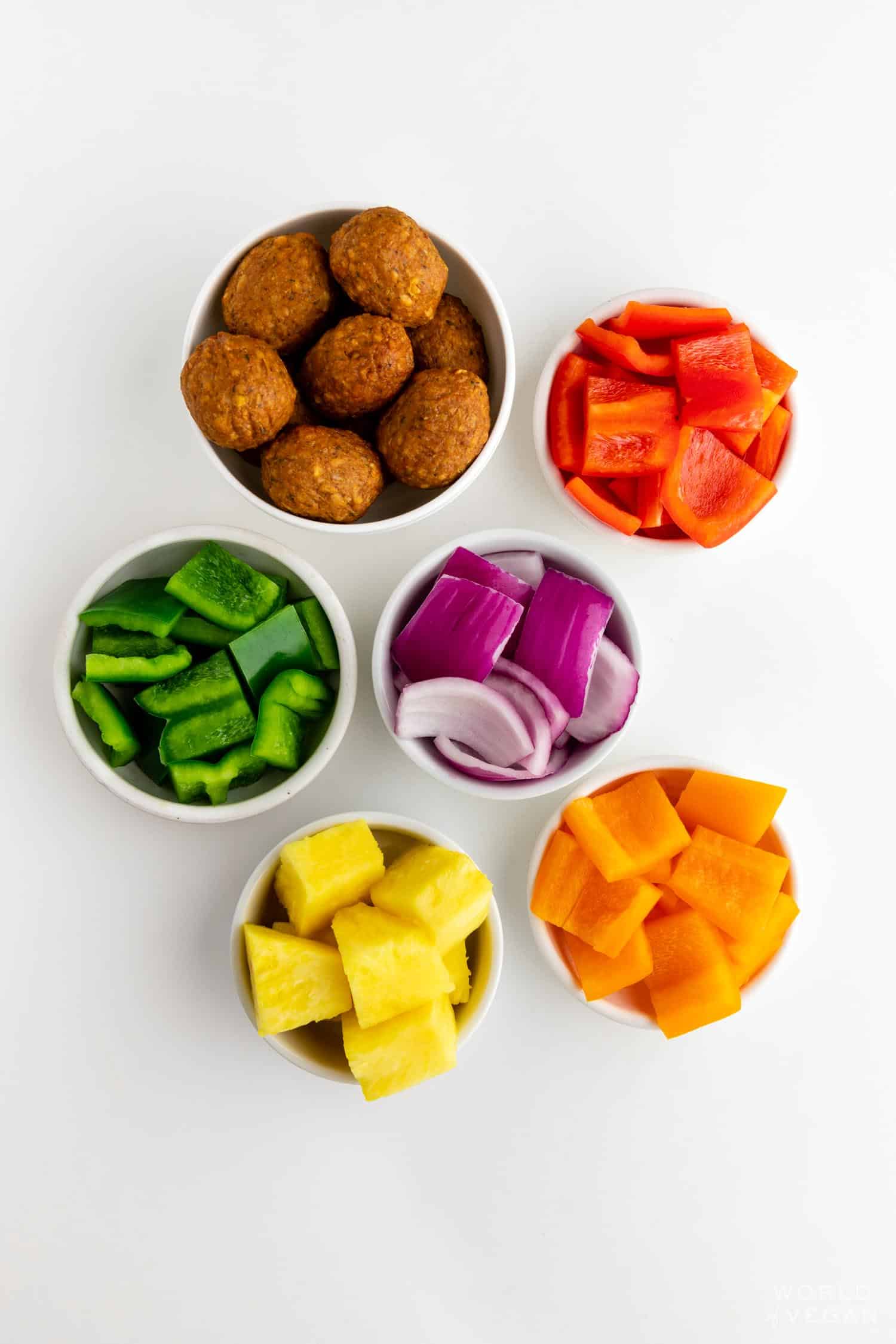 vegan kabob ingredients flatlay with veggie meatballs red onion bell pepper and pineapple