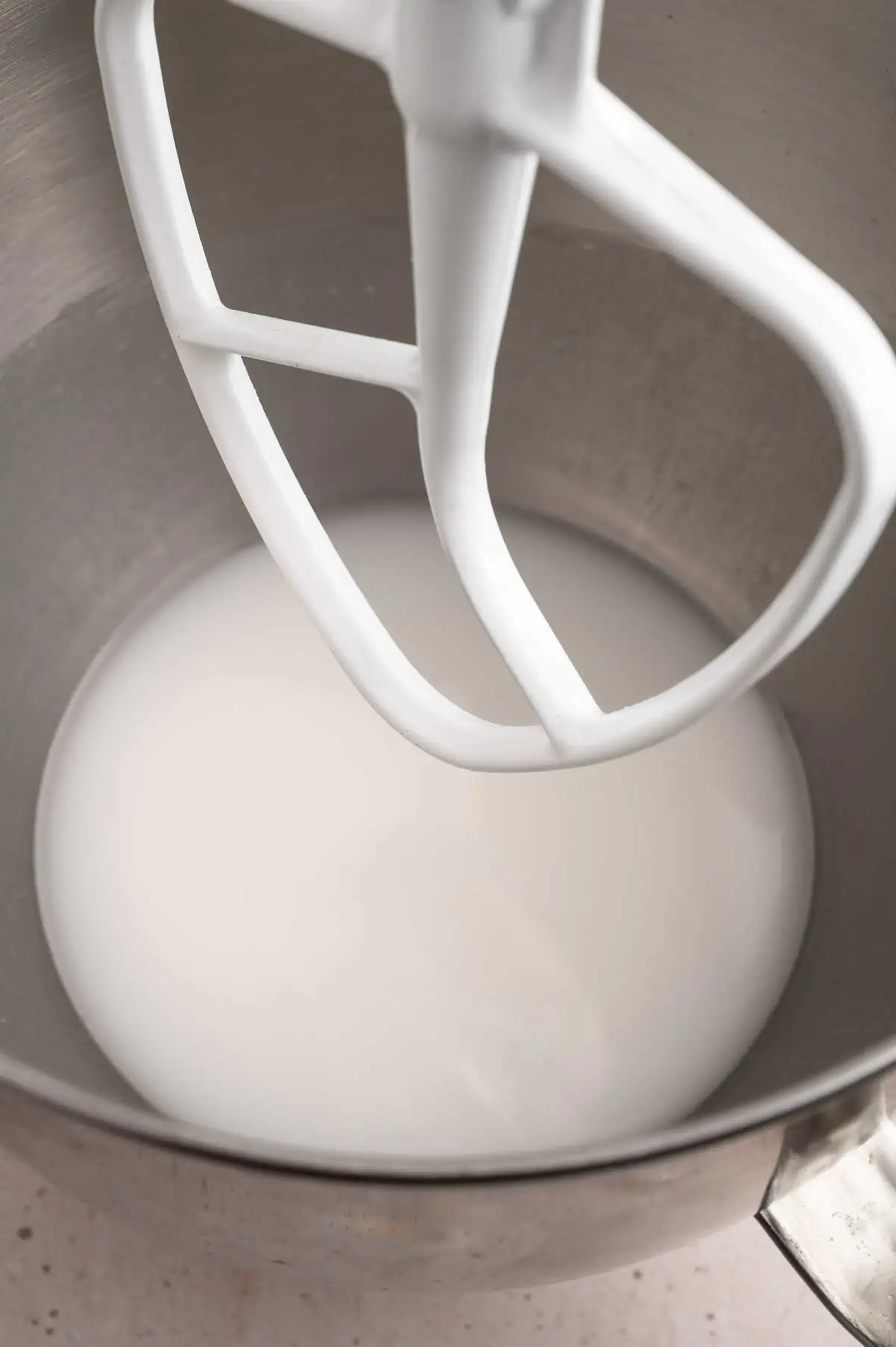 Coconut oil and powder sugar in a stand mixer bowl.