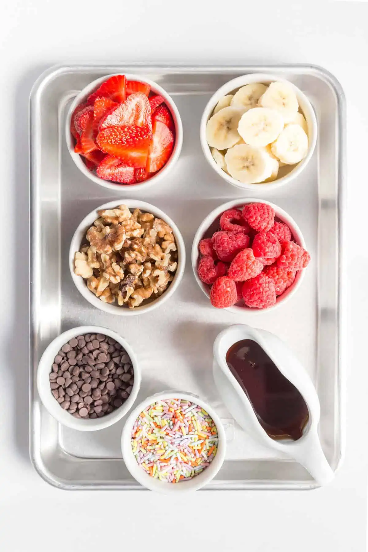Toppings for vegan sheet pancakes placed in small bowls.