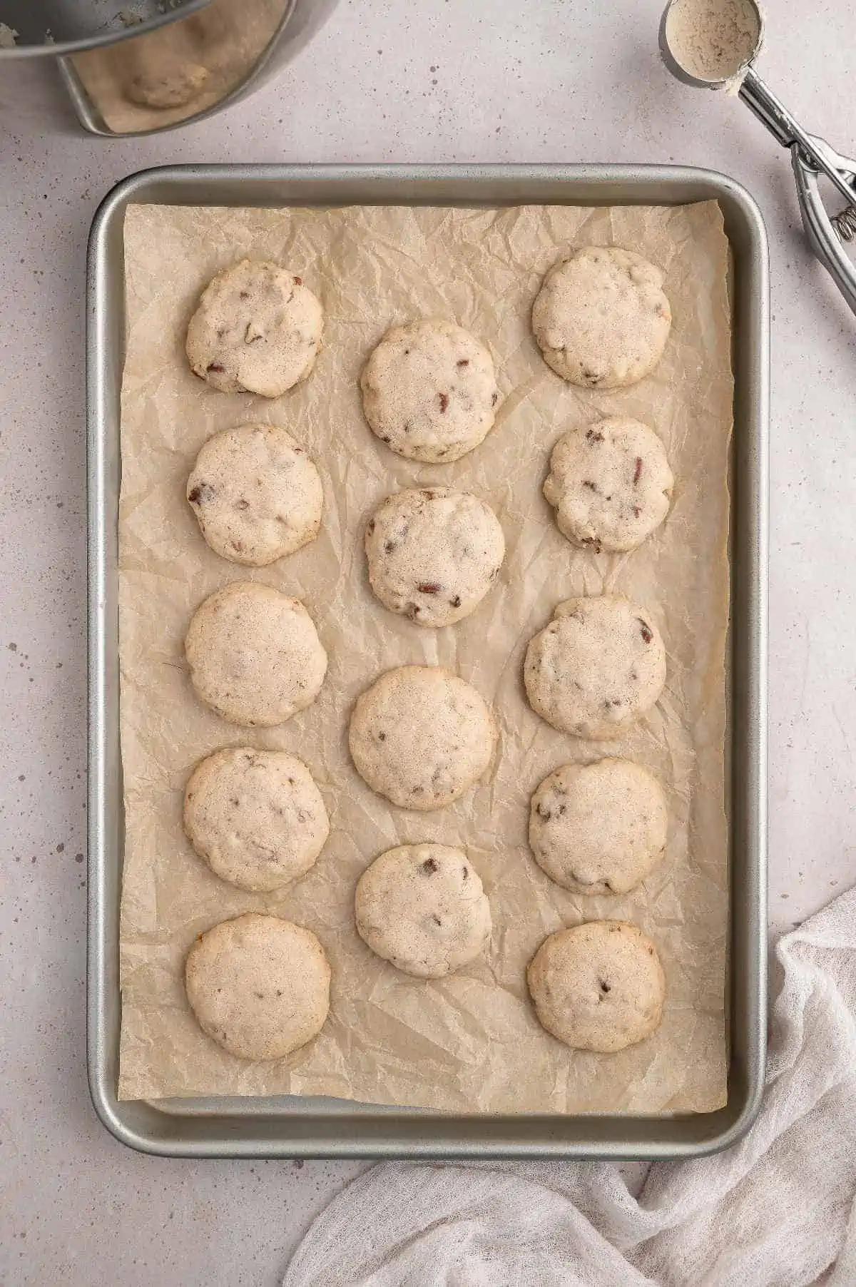 Mexican wedding cookies on a baking sheet after being baked.