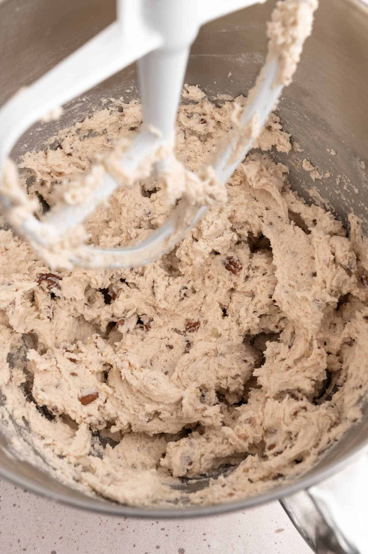 Batter for Mexican wedding cookies in a stander mixer bowl.