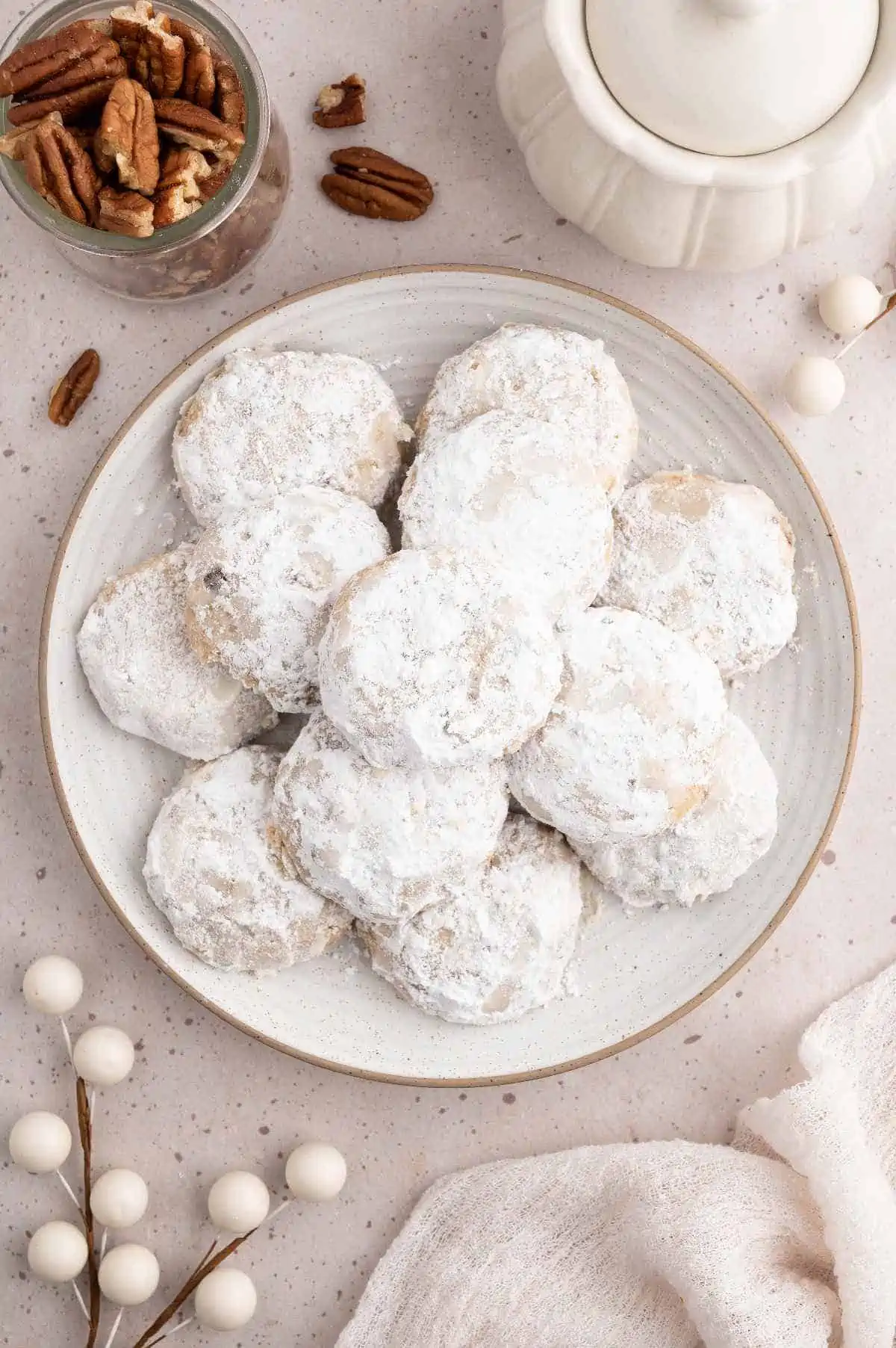 Vegan Mexican wedding cookies stacked on a plate.