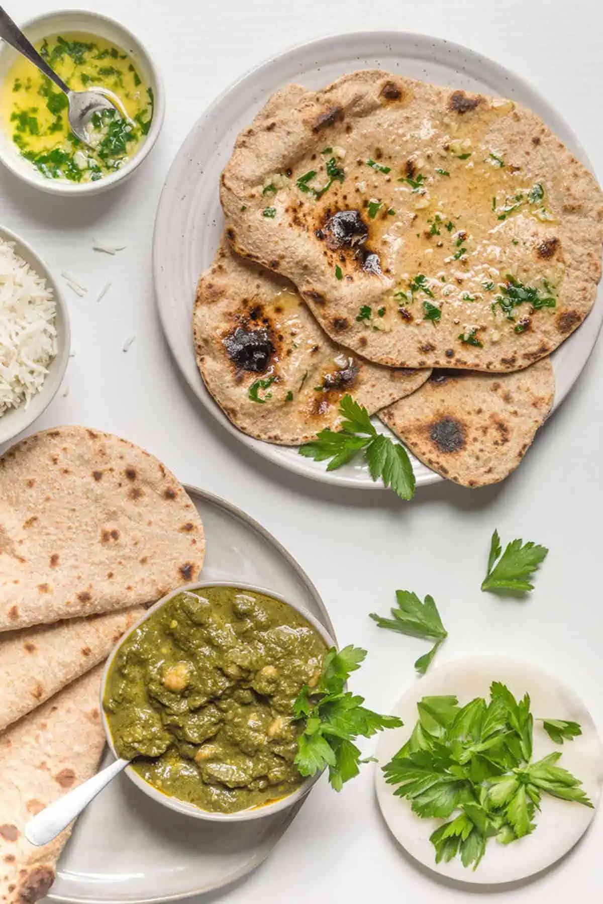 A plate stacked with vegan roti bread served with dipping sauces. 