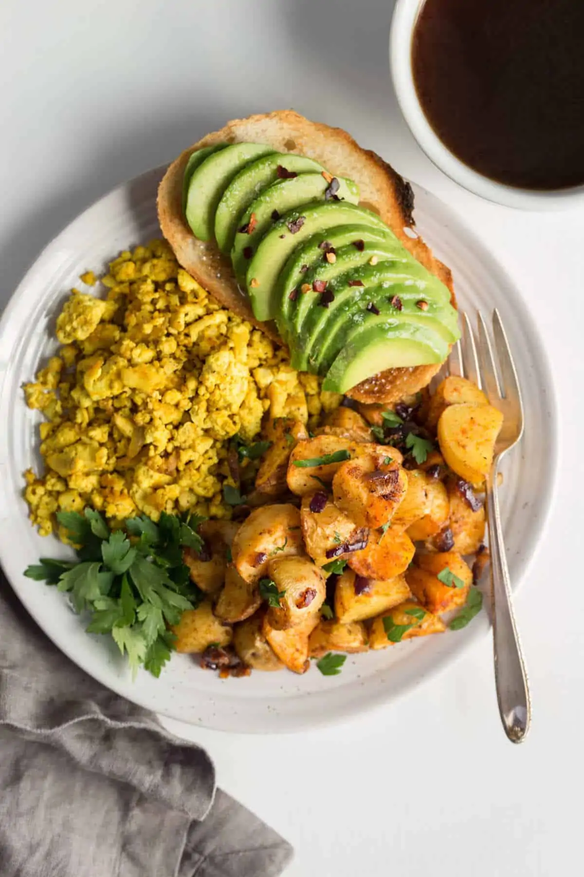Air fryer home fries on a plate served with tofu scramble and avocado toast.