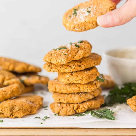 A stack of veggie nuggets with hand picking up a nugget.