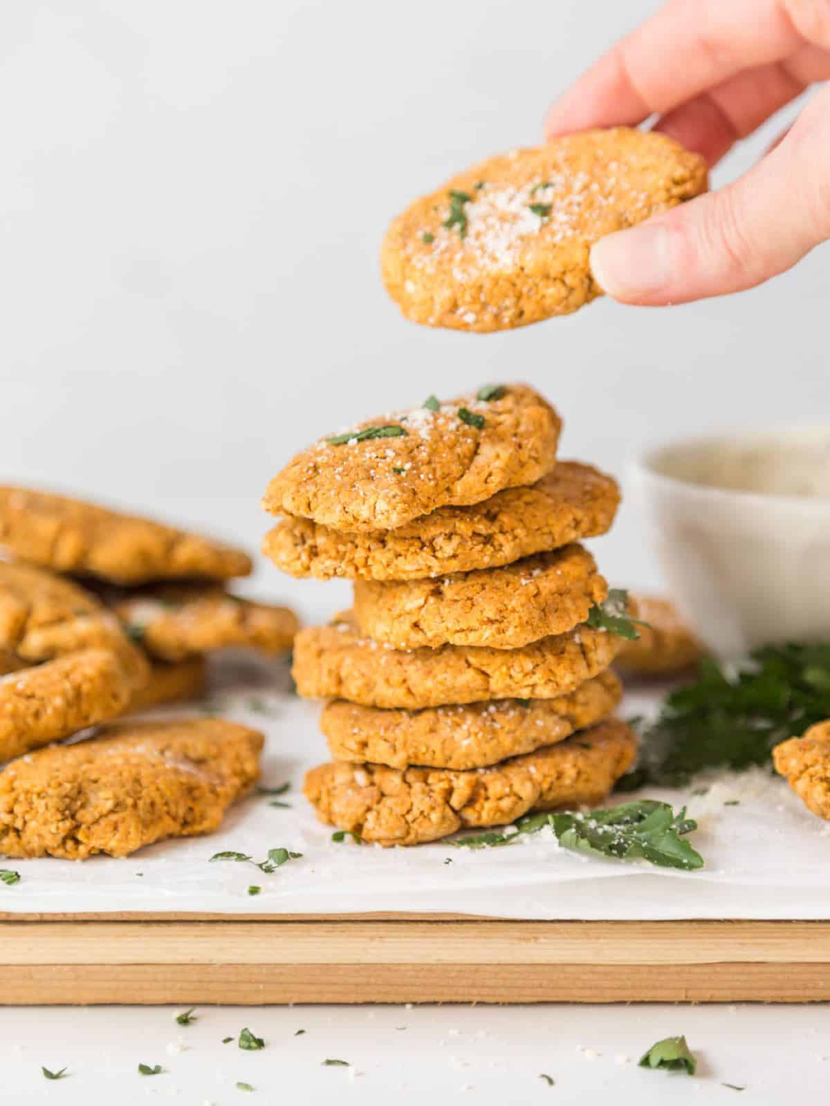 A stack of veggie nuggets with hand picking up a nugget.