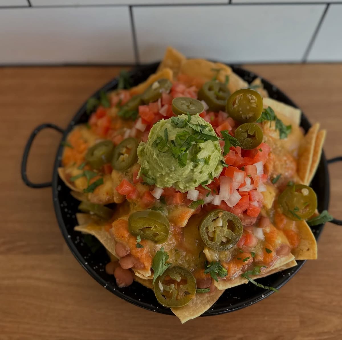 Vegan nachos with toppings at Taqueria La Venganza, a Mexican street food spot in Oakland.