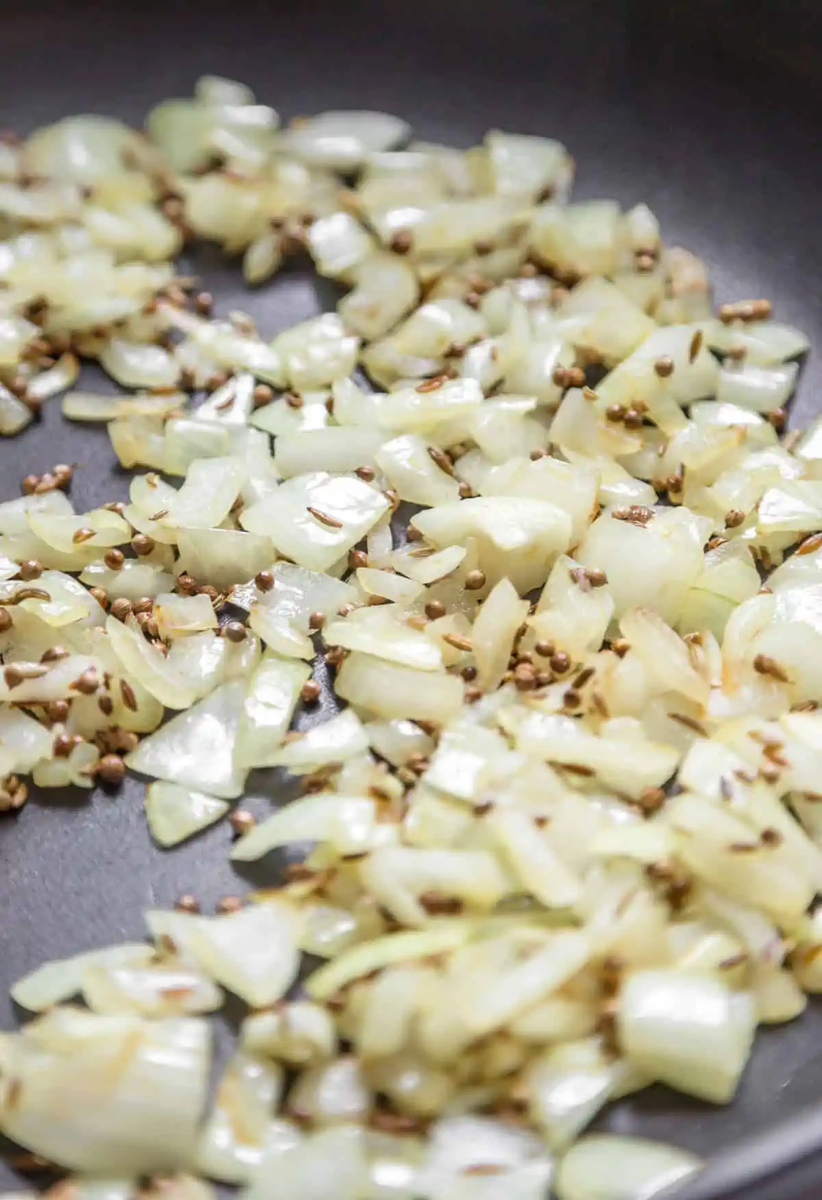 Onions sauteeing in a large skillet.