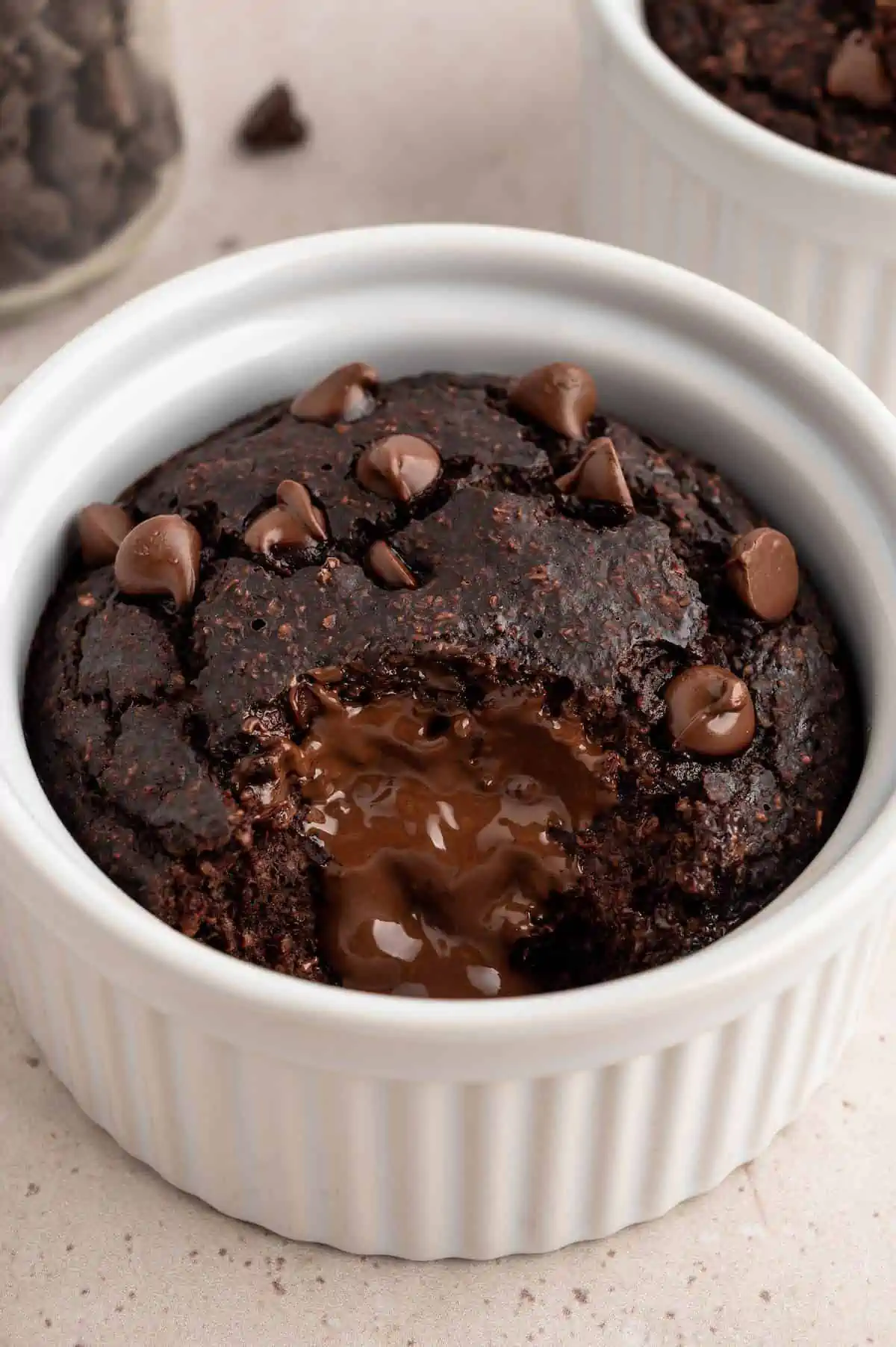 Chocolate baked oats protein mug cake with a bite missing and melted chocolate revealed.