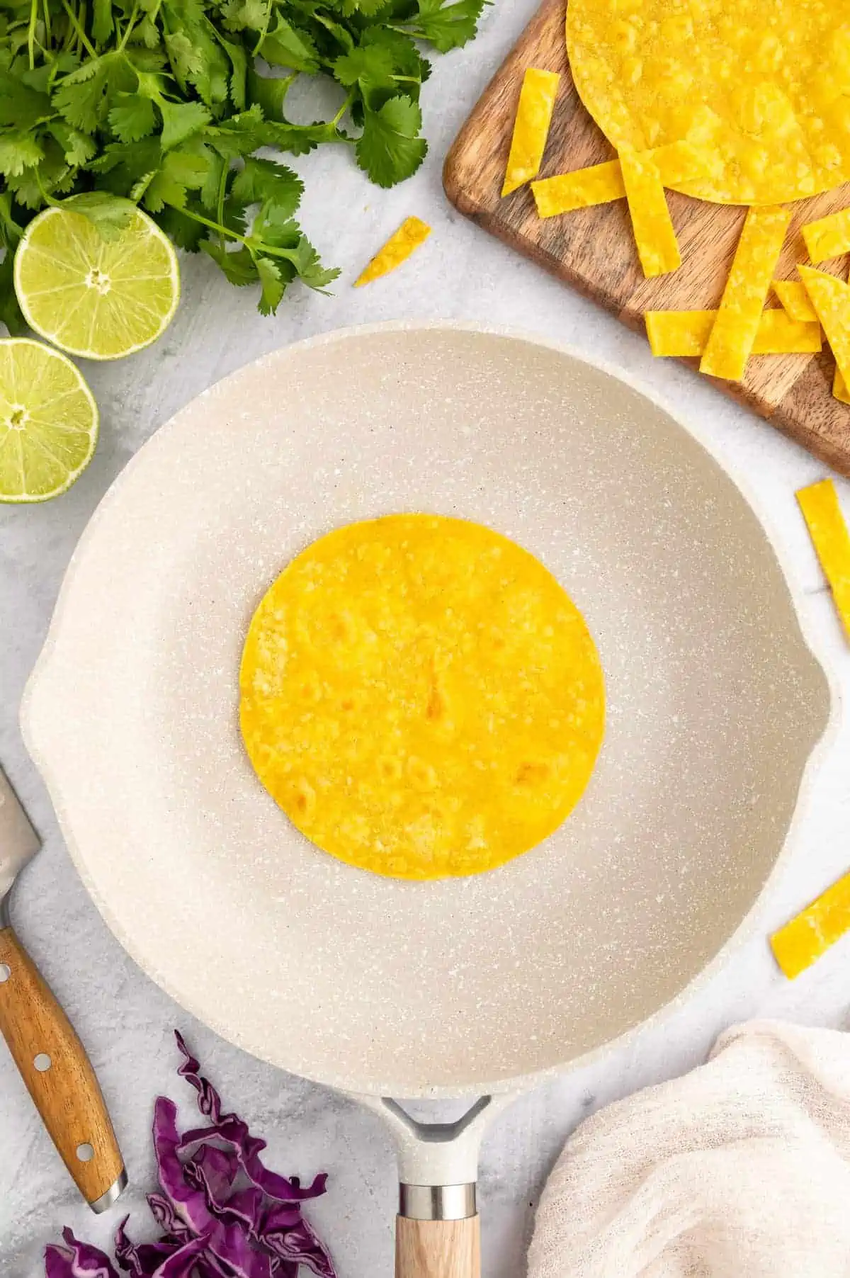 A corn tortilla in a white skillet.