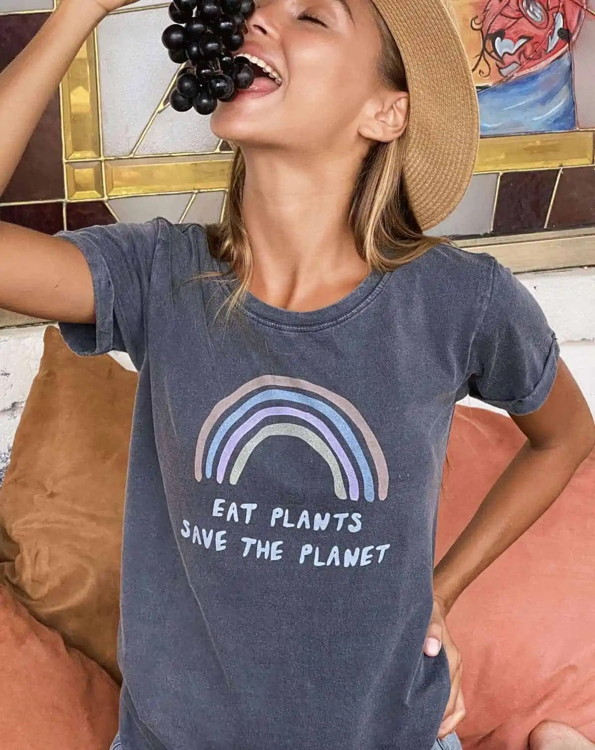 woman eating grapes wearing in the soulshine vegan shirt that says eat plants save the planet