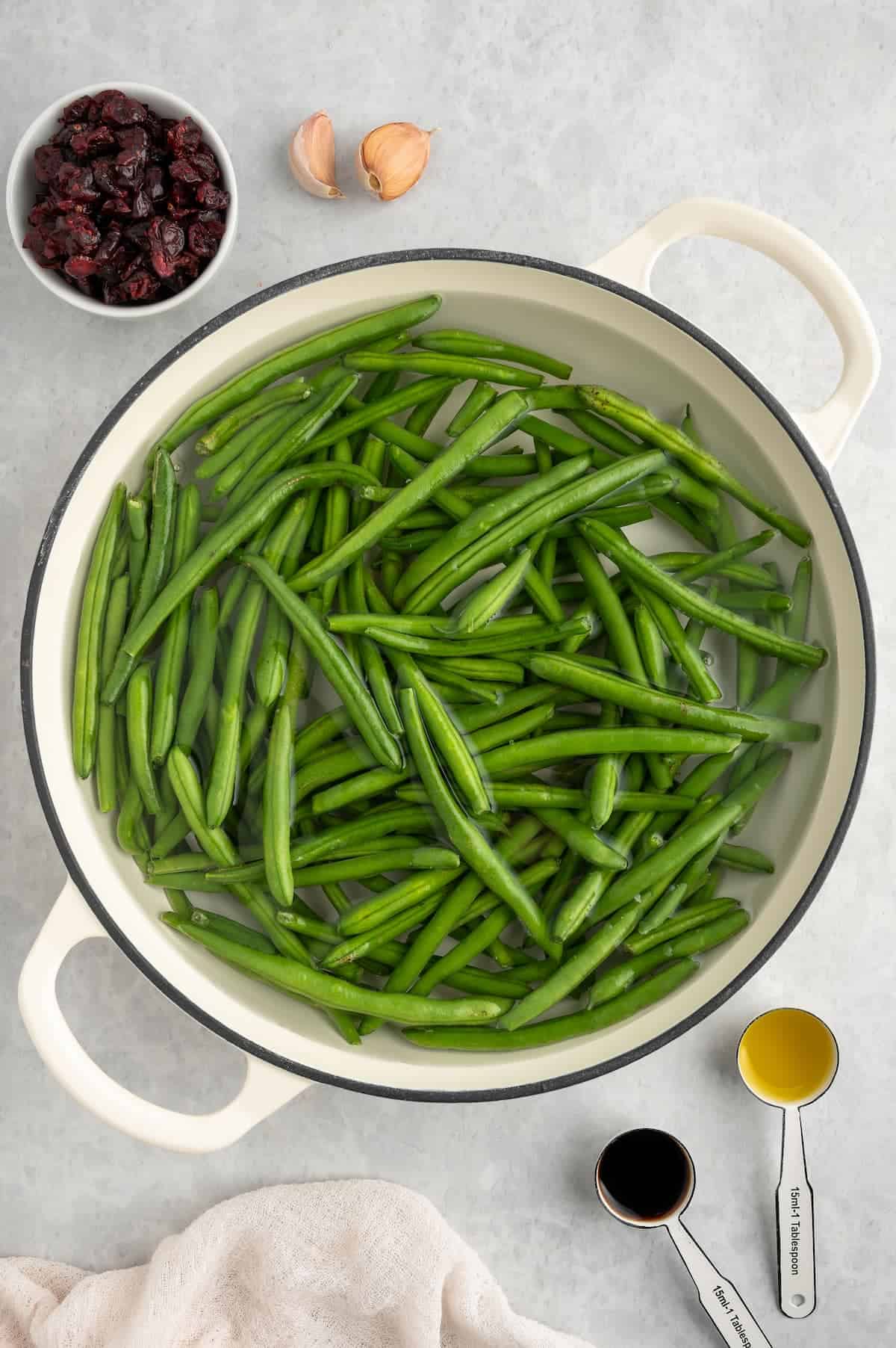 A Dutch oven with green beans in water.