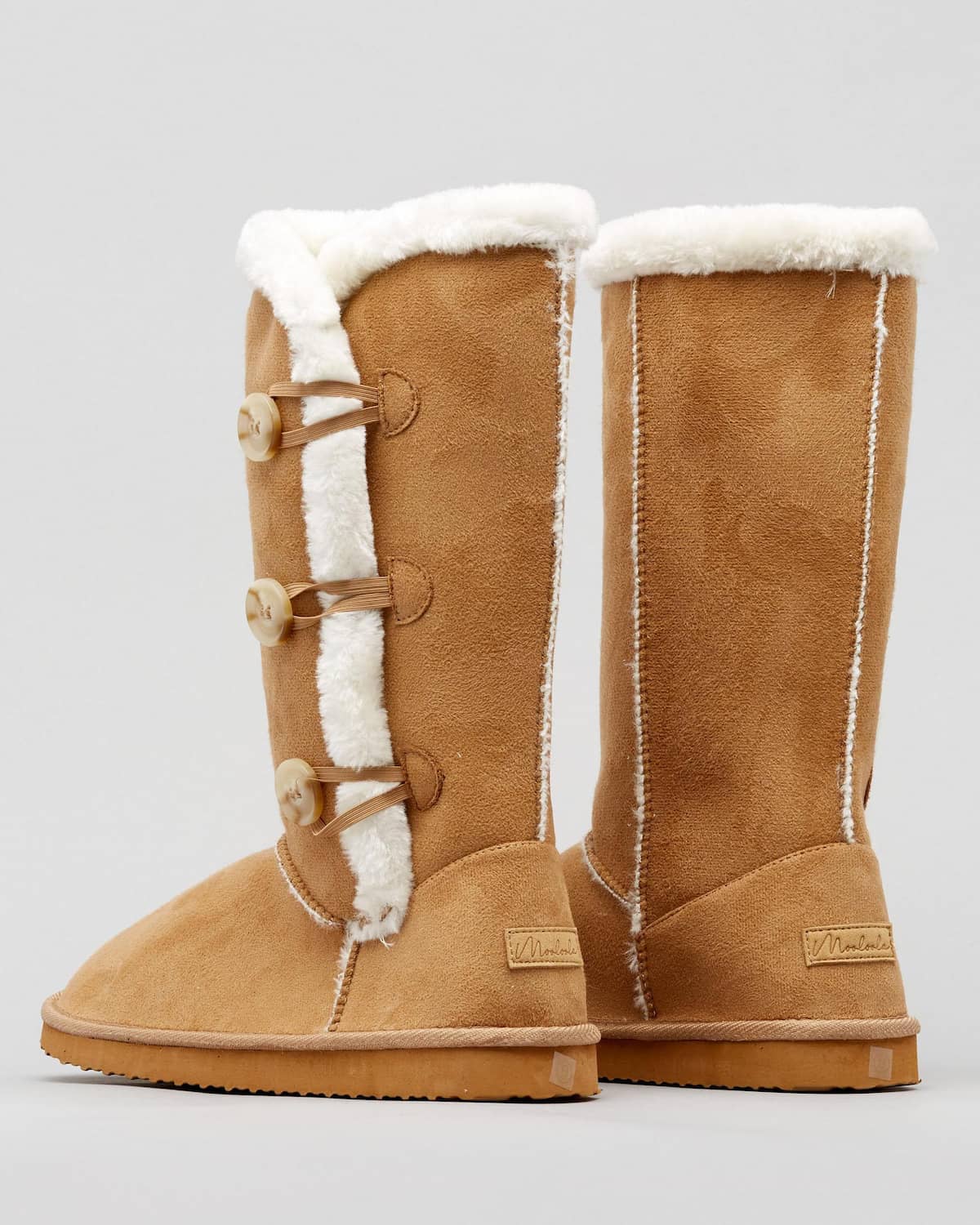 A pair of tall vegan Ugg-style slipper boots with a faux fur lining.