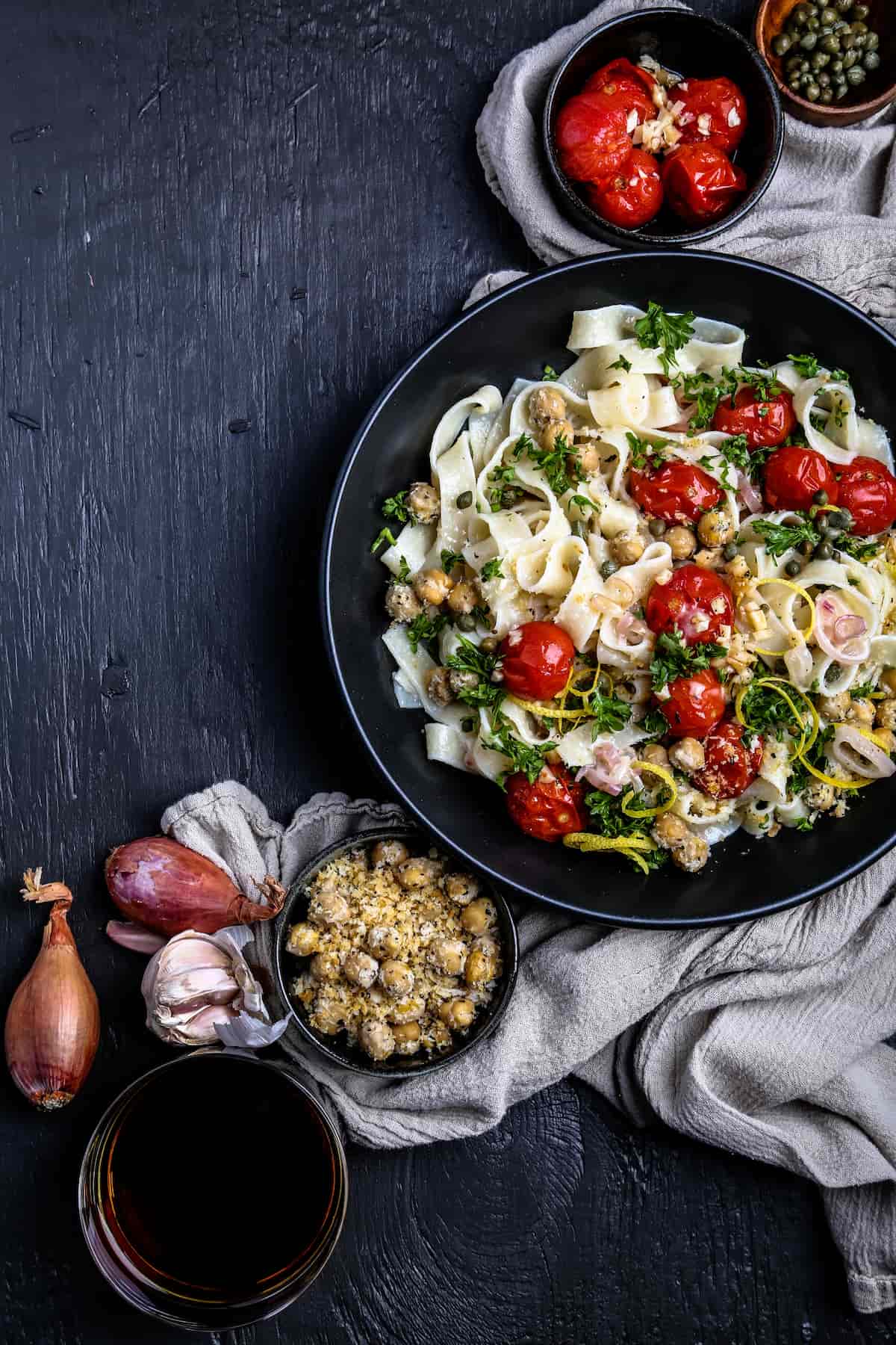 Bowl of pasta with roasted tomatoes, chickpeas, lemon zest, parsley, and toasted panko.