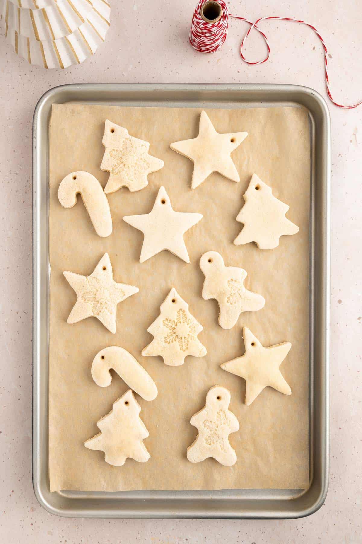 Holiday shaped salt cough ornaments on baking sheet after baking.