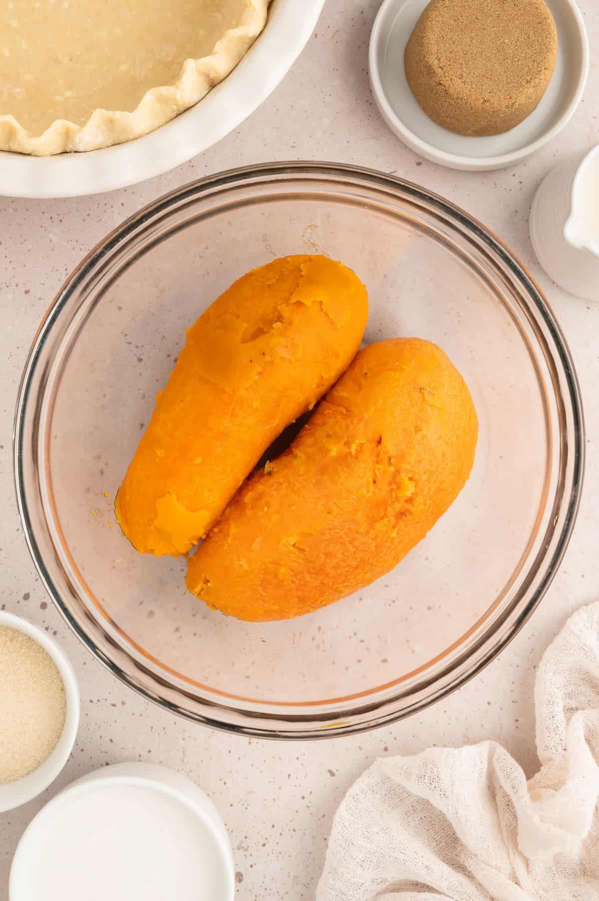 Two peeled sweet potatoes in a bowl.