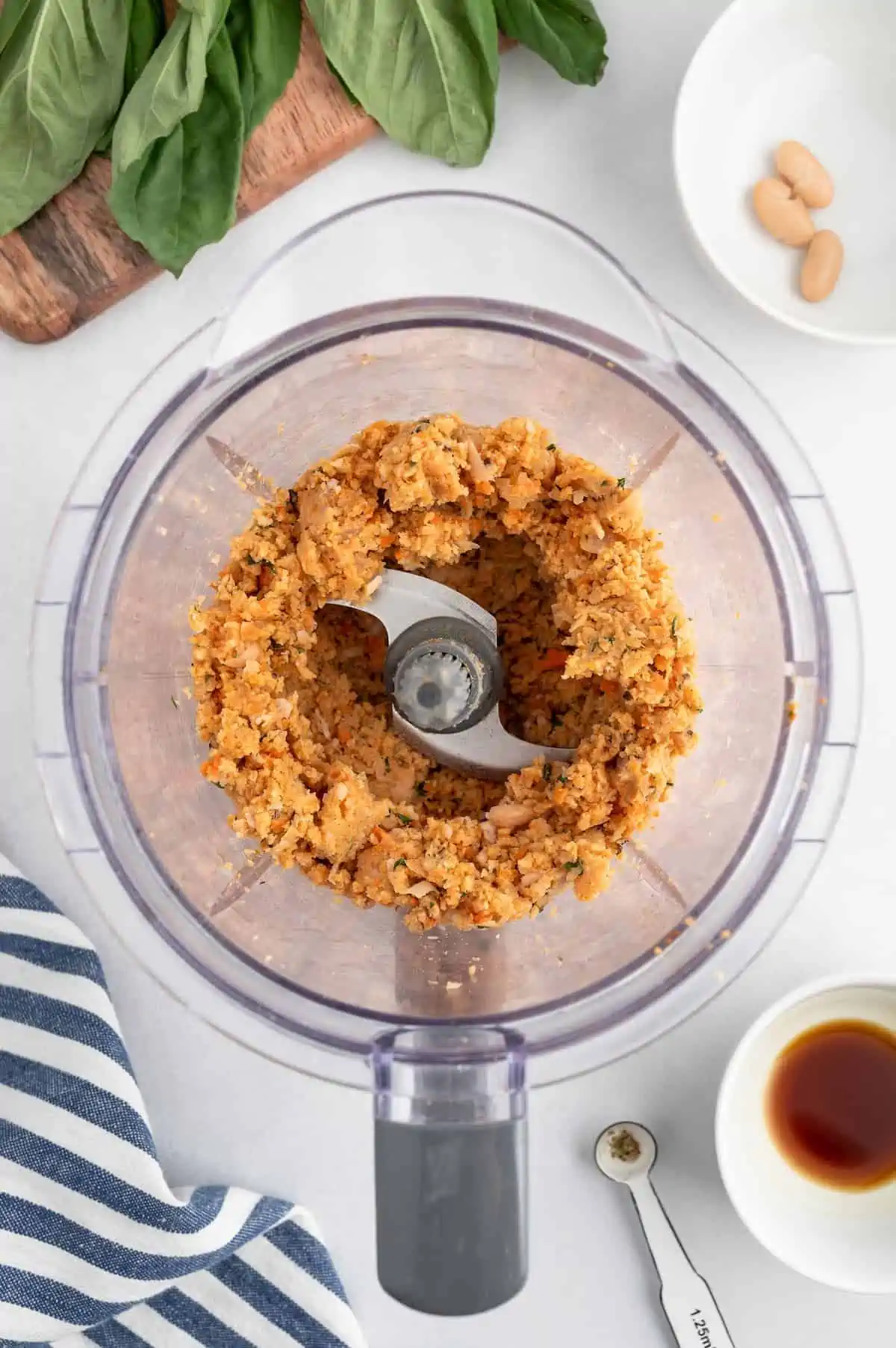 A top-down shot of veggie meatball ingredients processed in a food processor.